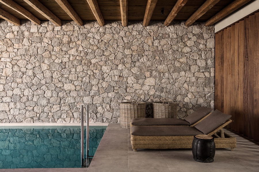 Khu vực hồ bơi “trong nhà” được cấu thành chủ yếu từ đá và gỗ
